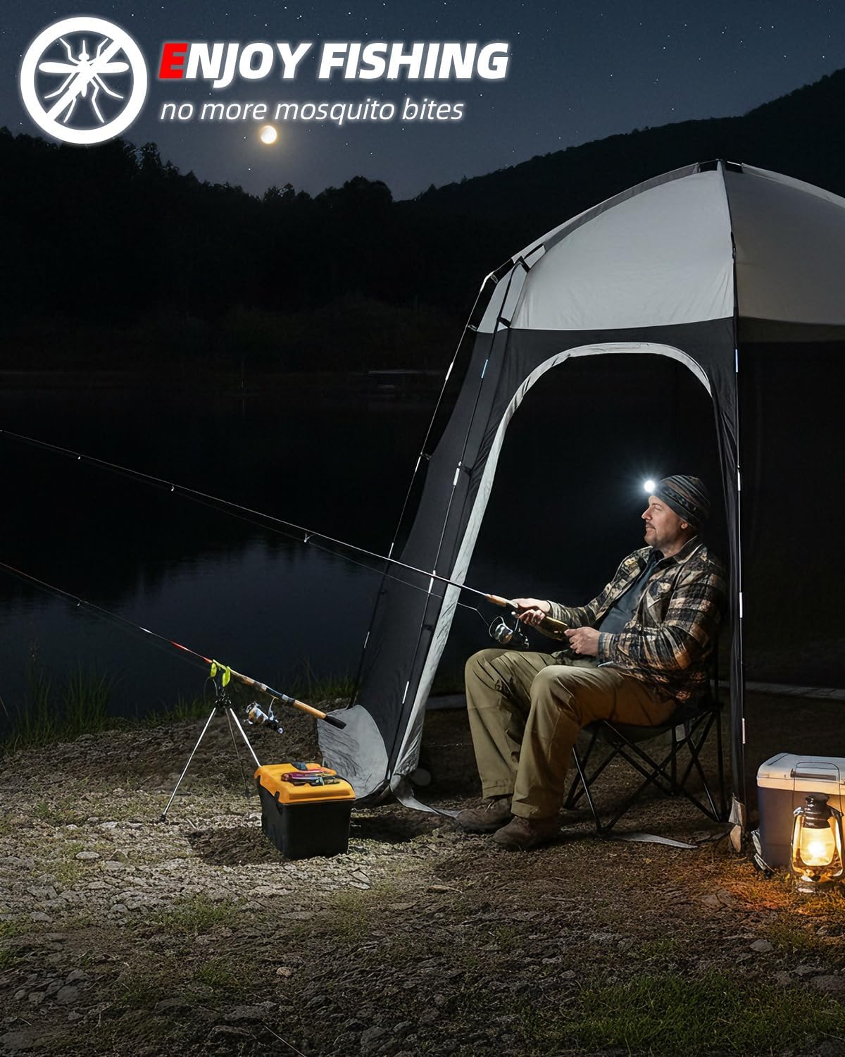 A man sits inside a black and white fishing tent at night by a lake, holding a fishing rod. The scene includes a cooler, lantern, and a visible mosquito logo with the text 'ENJOY FISHING no more mosquito bites' in the upper left corner.