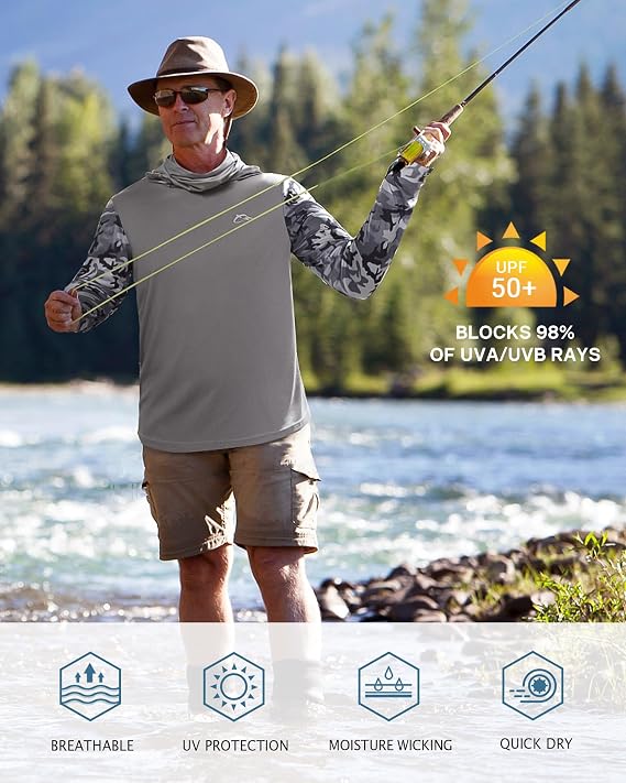 A man stands by a river wearing a long-sleeve UV protection fishing shirt with a gray body and camouflage sleeves, khaki shorts, and a hat, holding a fly fishing rod. Text overlays highlight UPF 50+ sun protection, and a banner at the bottom lists breathable, UV protection, moisture wicking, and quick dry features.