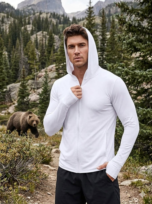 Man wearing a white hoodie in a forest with a bear in the background Big Green Bear