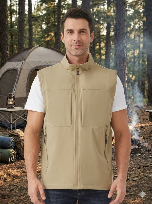 A man wearing a tan zip-up sleeveless vest over a white t-shirt, standing in a forest campsite setting with a tent and fire pit in the background. big green bear Biggreenbear.com