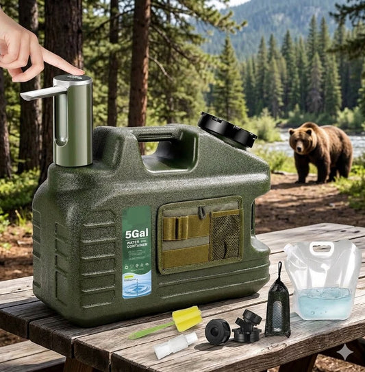 An outdoor camping water filter pitcher set displayed on a wooden picnic table in a forest setting, with a bear in the background. The set includes an olive green 5-gallon water container, a silver and green manual pump, a clear plastic pitcher with blue water, and various filter cartridges and accessories. big green bear Biggreenbear.com
