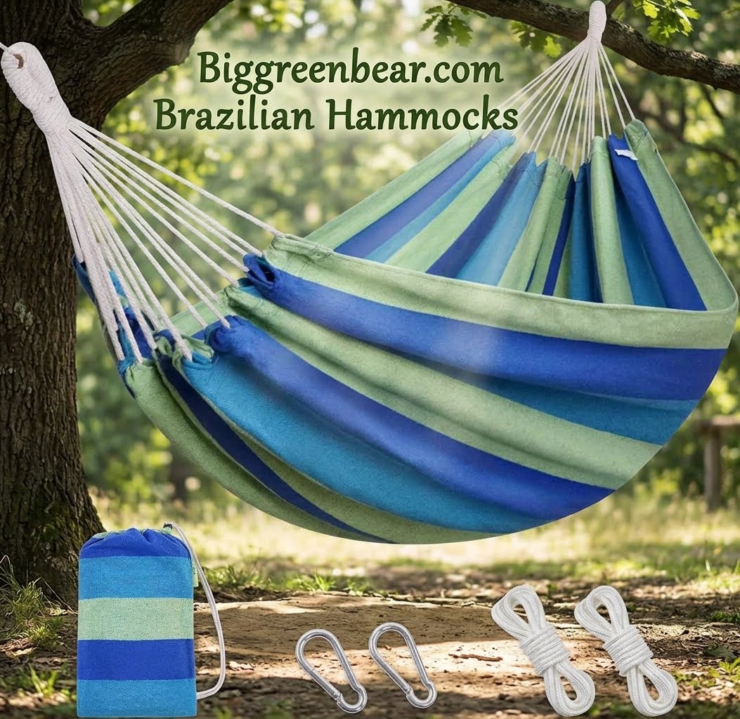 A striped hammock in shades of blue, teal, and green hangs from white ropes between two trees outdoors. A matching small storage pouch, two white carabiners, and two folded white ropes are placed below on the ground.