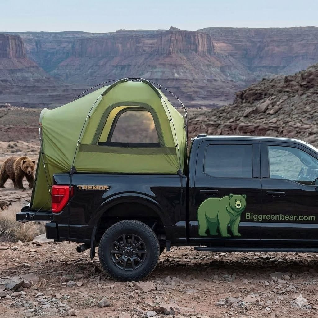 Black truck with a green tent on the back in a desert landscape, featuring 'Big Green Bear' branding.
