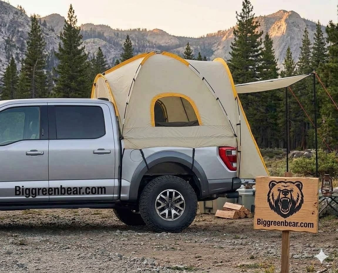 Pickup truck with a tent attached in a mountainous camping area, featuring Biggreenbear.com branding.