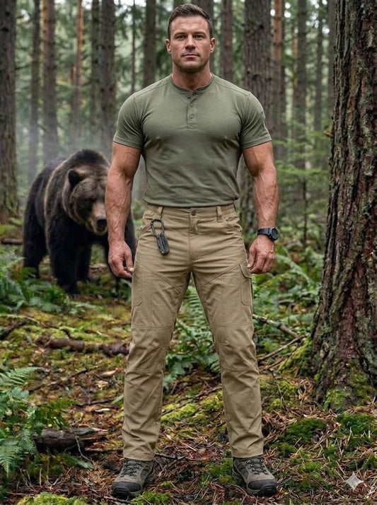 Man in green shirt and beige pants standing in a forest with a bear in the background Big Green Bear