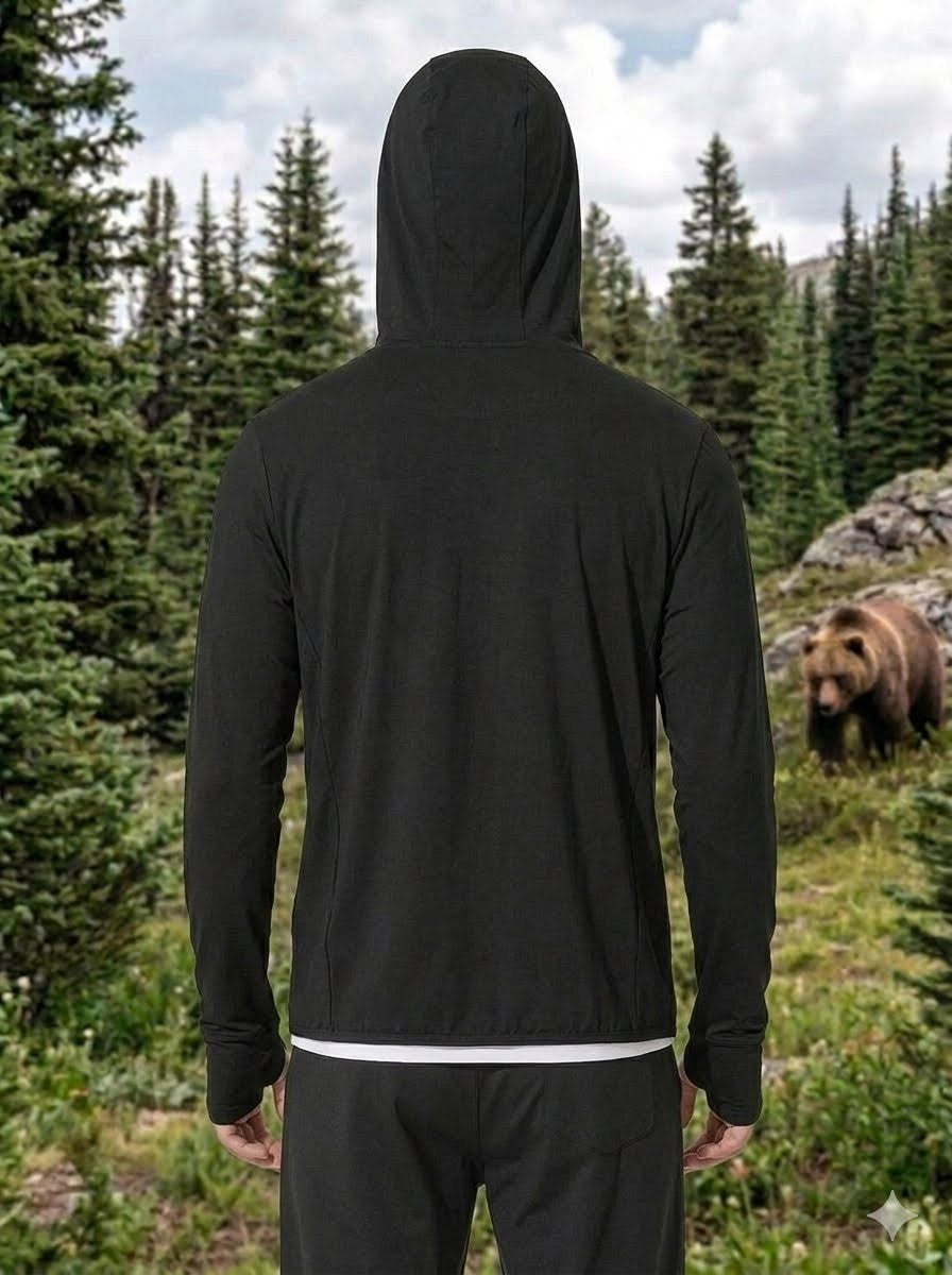 Person wearing a black hoodie with a bear in the background