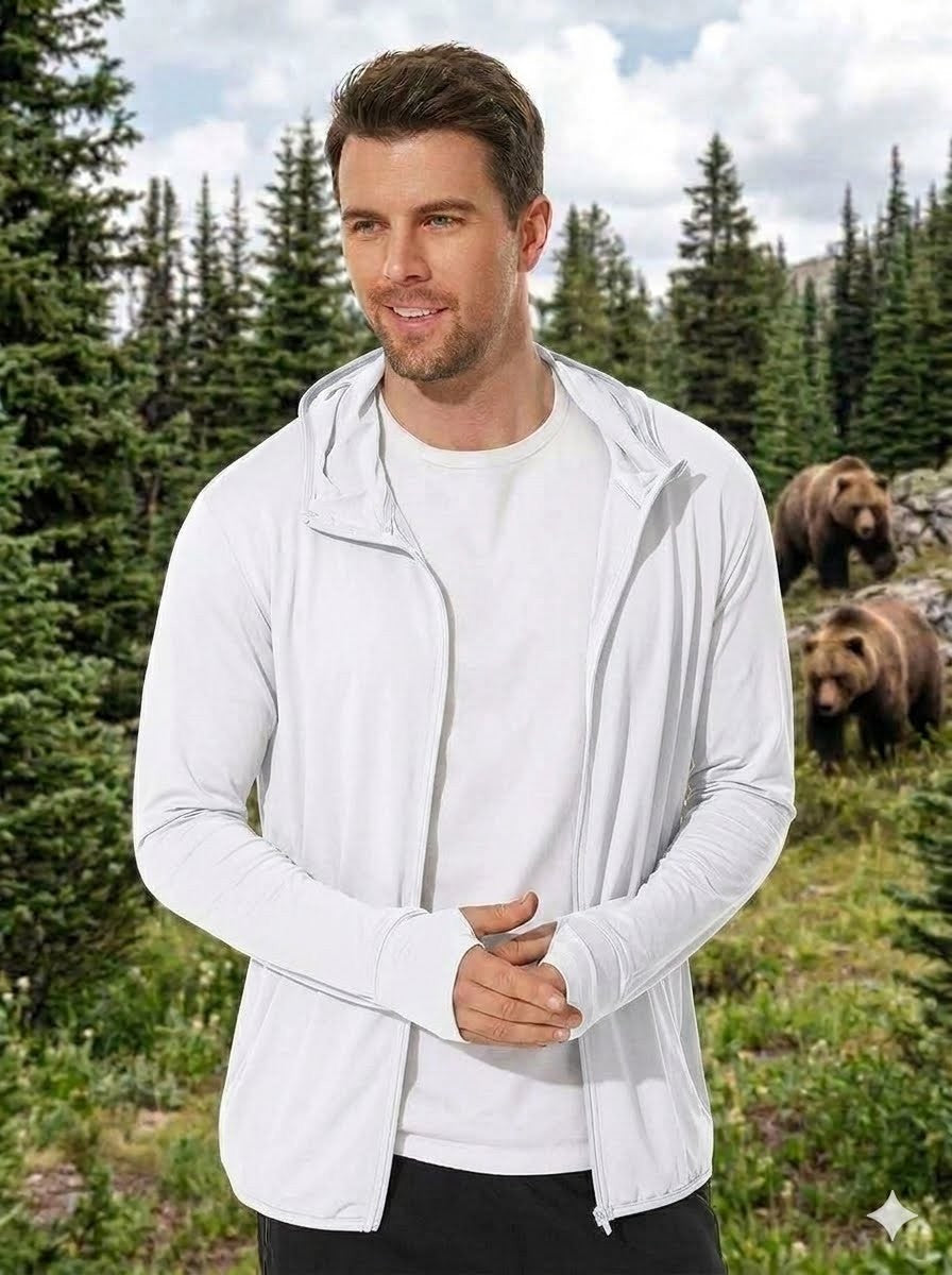Man wearing a white jacket standing in a forest with bears in the background Big Green Bear