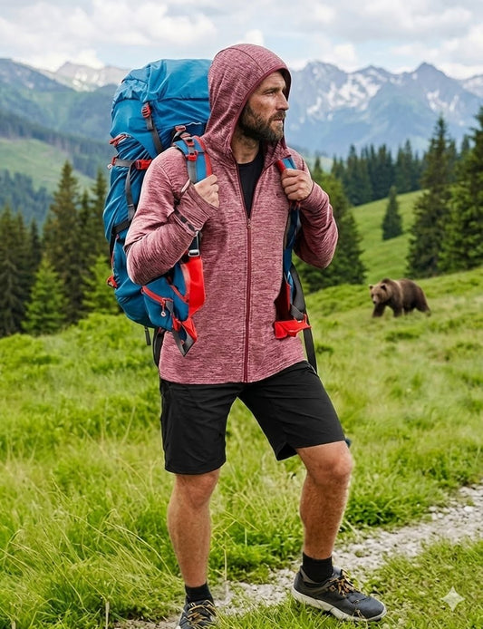 Man with a large blue backpack hiking in a mountainous area with a bear in the background Big Green Bear