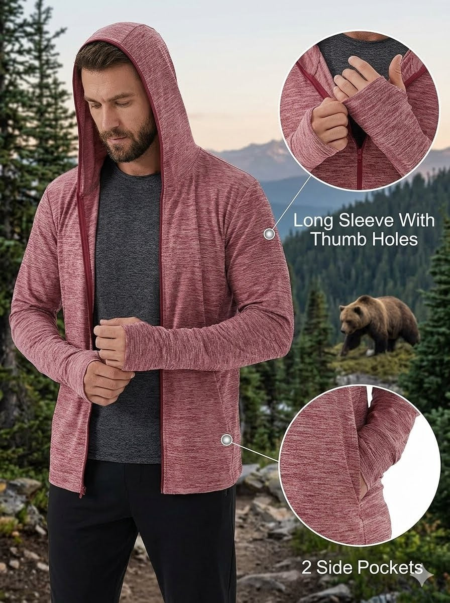 Man wearing a maroon hoodie with long sleeves and thumb holes, standing in a forest with a bear in the background.