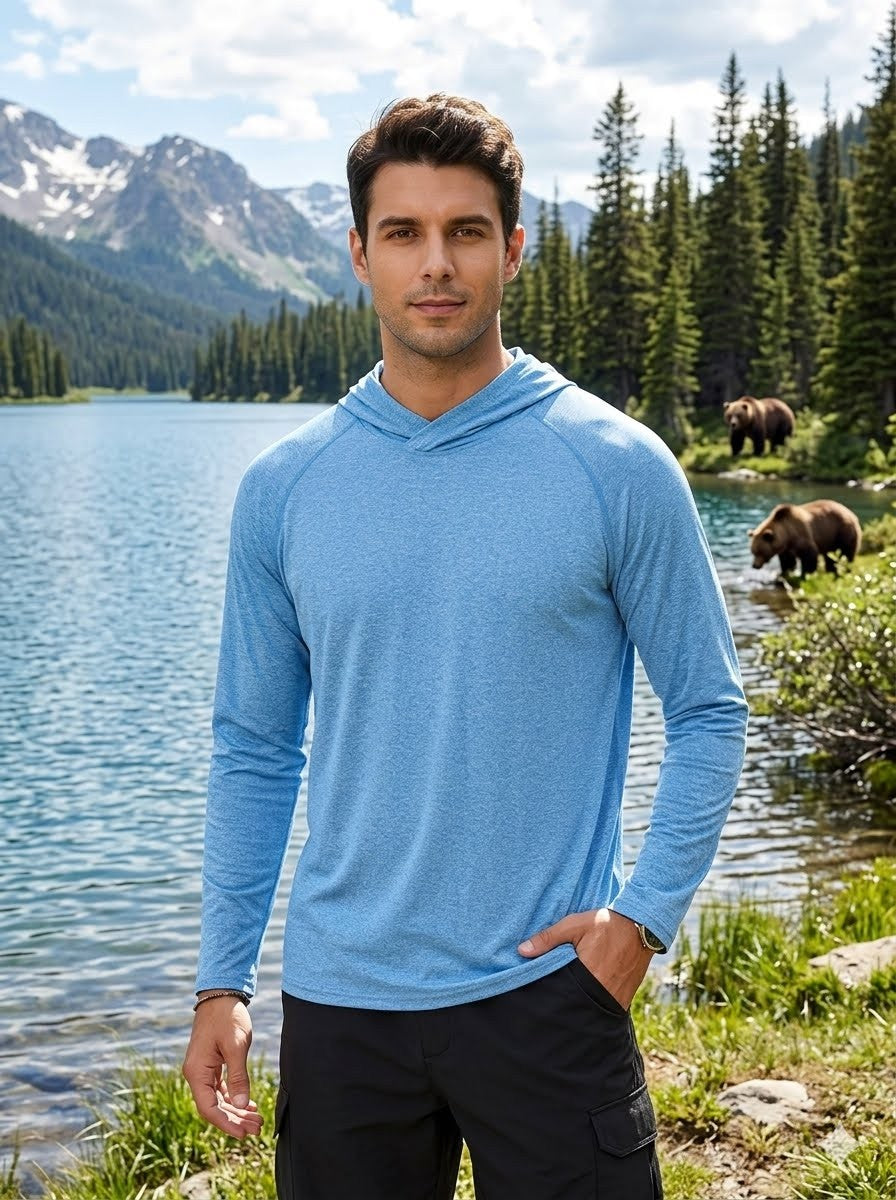Man in a blue hoodie standing by a lake with bears in the background Big green bear