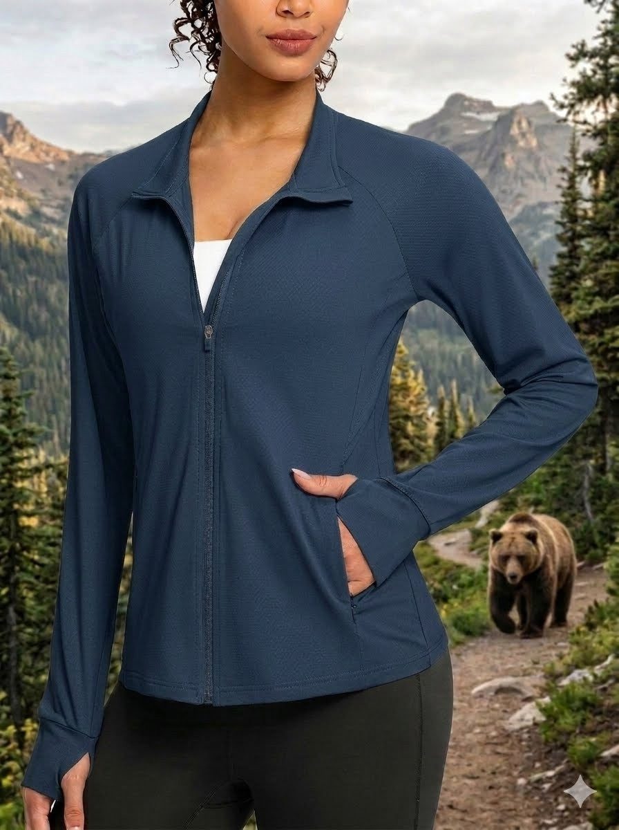 Person wearing a blue jacket with a bear and mountainous landscape in the background big green bear
