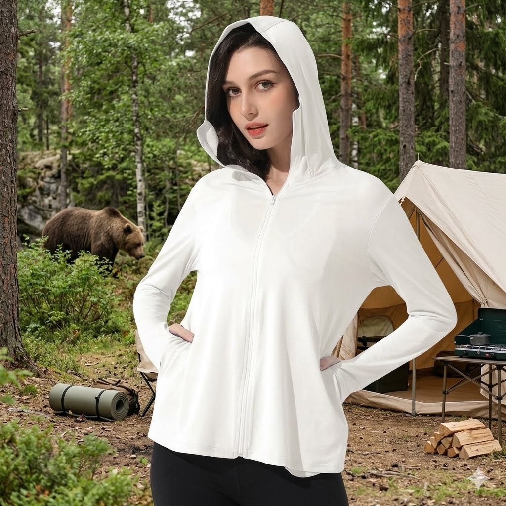 Woman wearing a white hoodie in a forest with a bear in the background
