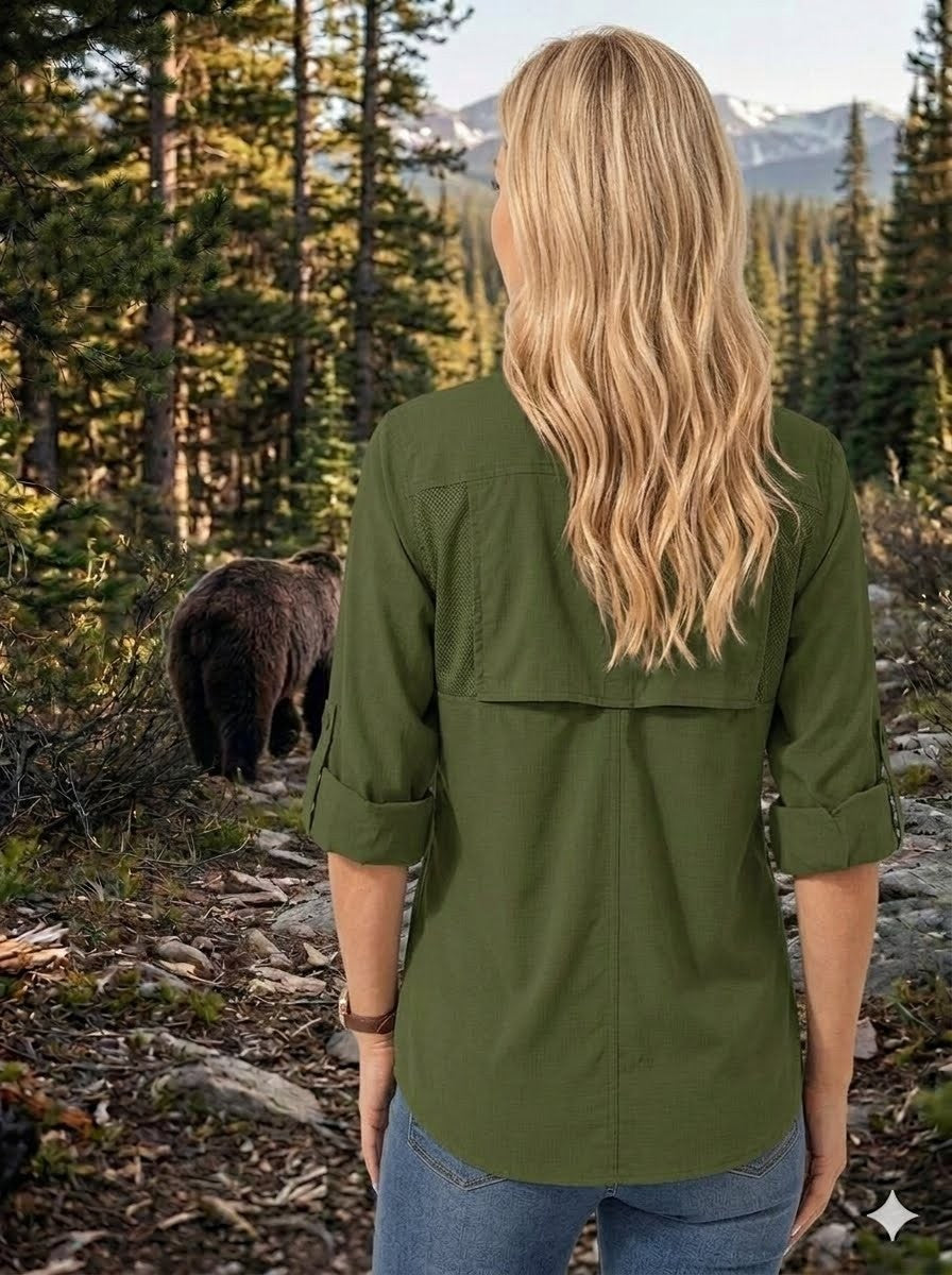 Person wearing a green jacket in a forest with a bear in the background 
