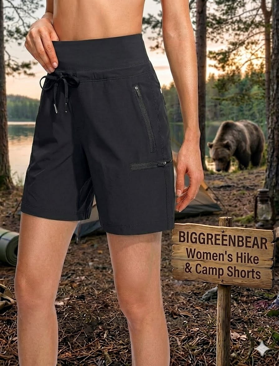 Person wearing black shorts with a bear and camping gear in the background, next to a 'BIGGREENBEAR Women's Hike & Camp Shorts' sign.