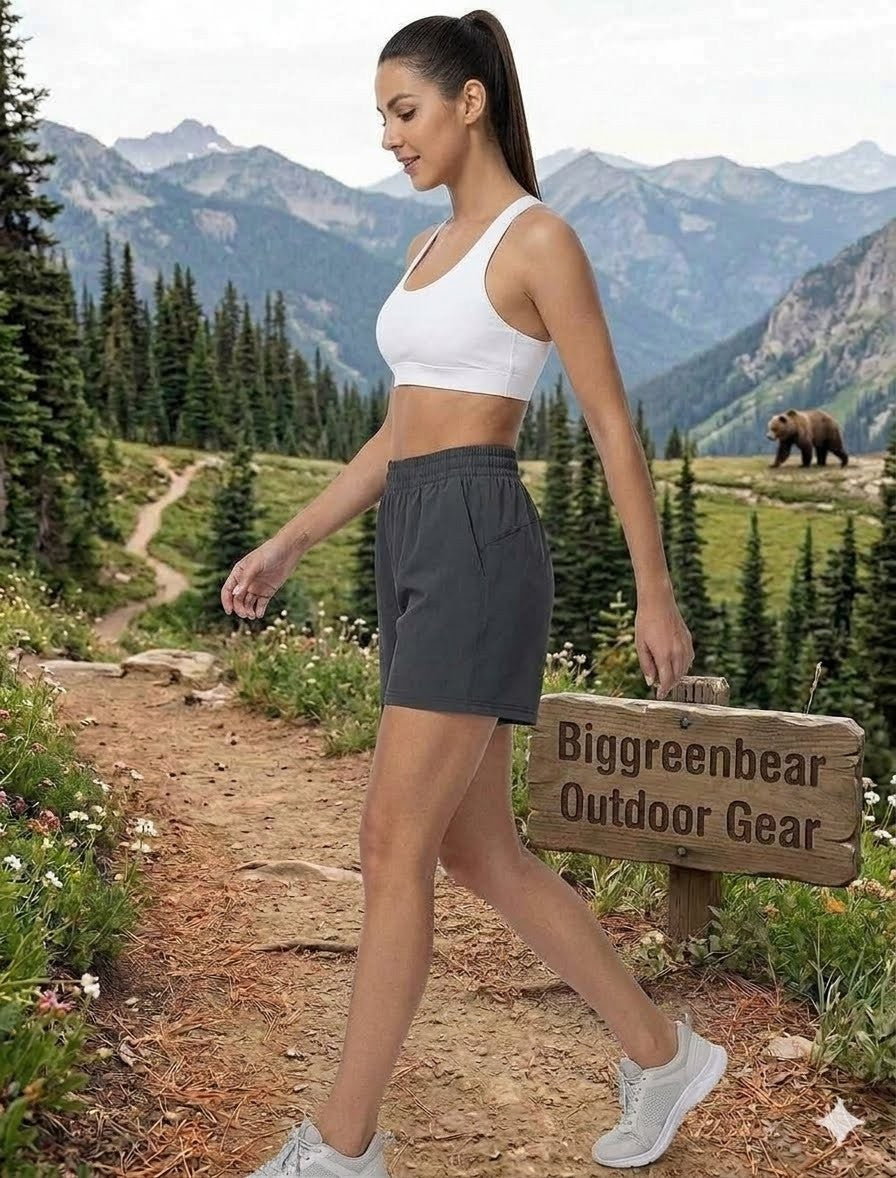 Woman walking on a trail with mountains in the background, carrying a 'Biggreenbear Outdoor Gear' sign.