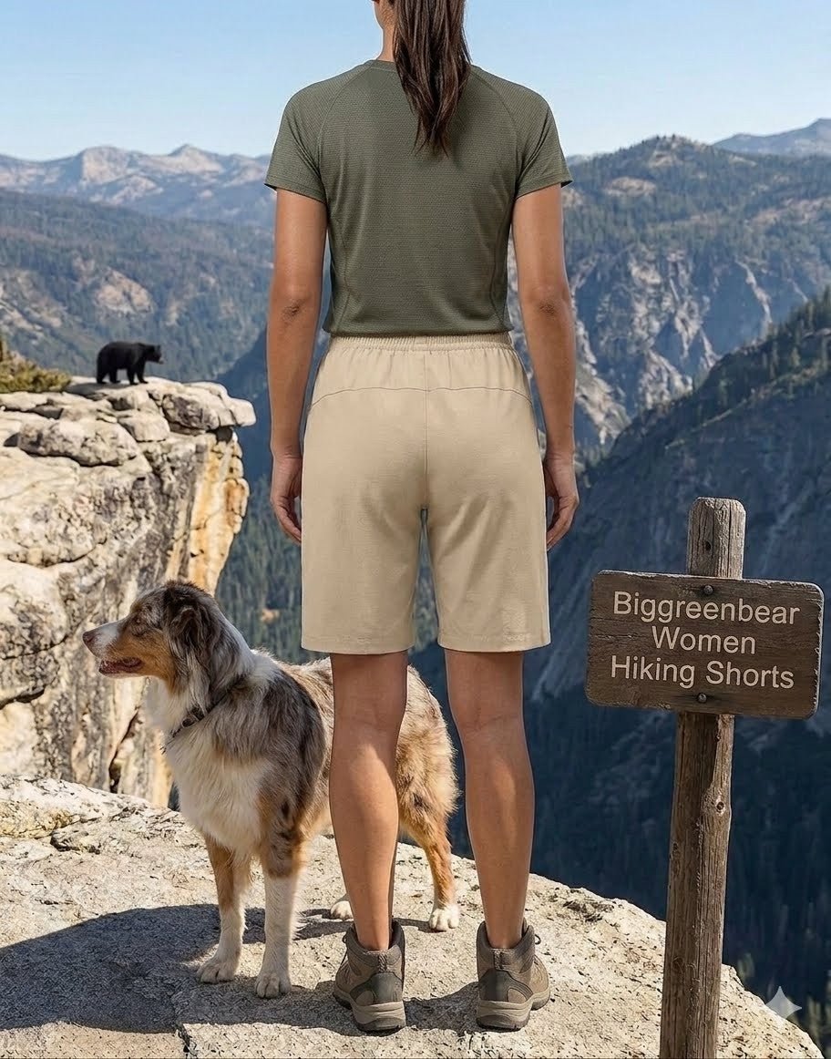 Person wearing green shirt and beige shorts standing on a mountain with a dog and a bear, next to a hiking sign.