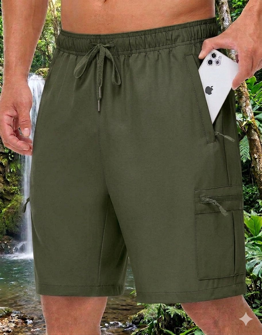 Olive green men's swim trunks with a drawstring waist and cargo pocket, shown on a model holding a white smartphone in front of a tropical waterfall background.