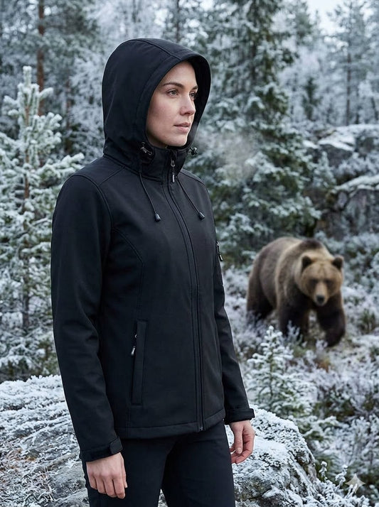 Person wearing a black jacket in a snowy forest with a bear in the background Big Green Bear