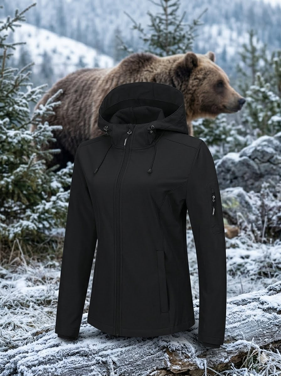 Person wearing a black jacket in a snowy forest with a bear in the background