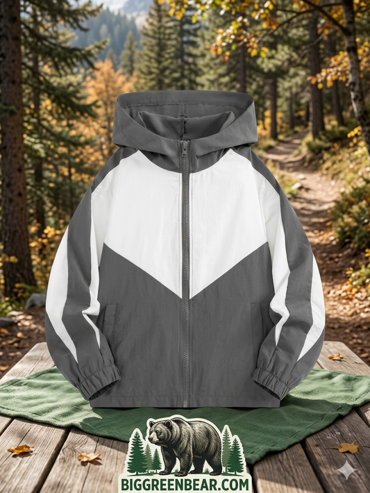 Gray and white jacket with a hood on a wooden surface in a forest setting, featuring the Big Green Bear logo.
