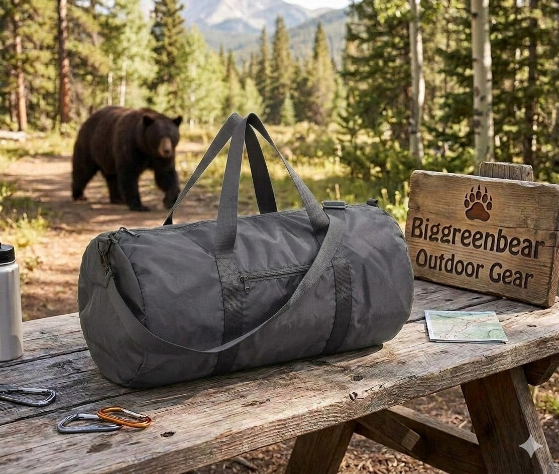 Gray duffel bag on a wooden bench with a bear in the background, featuring Biggreenbear Outdoor Gear branding.